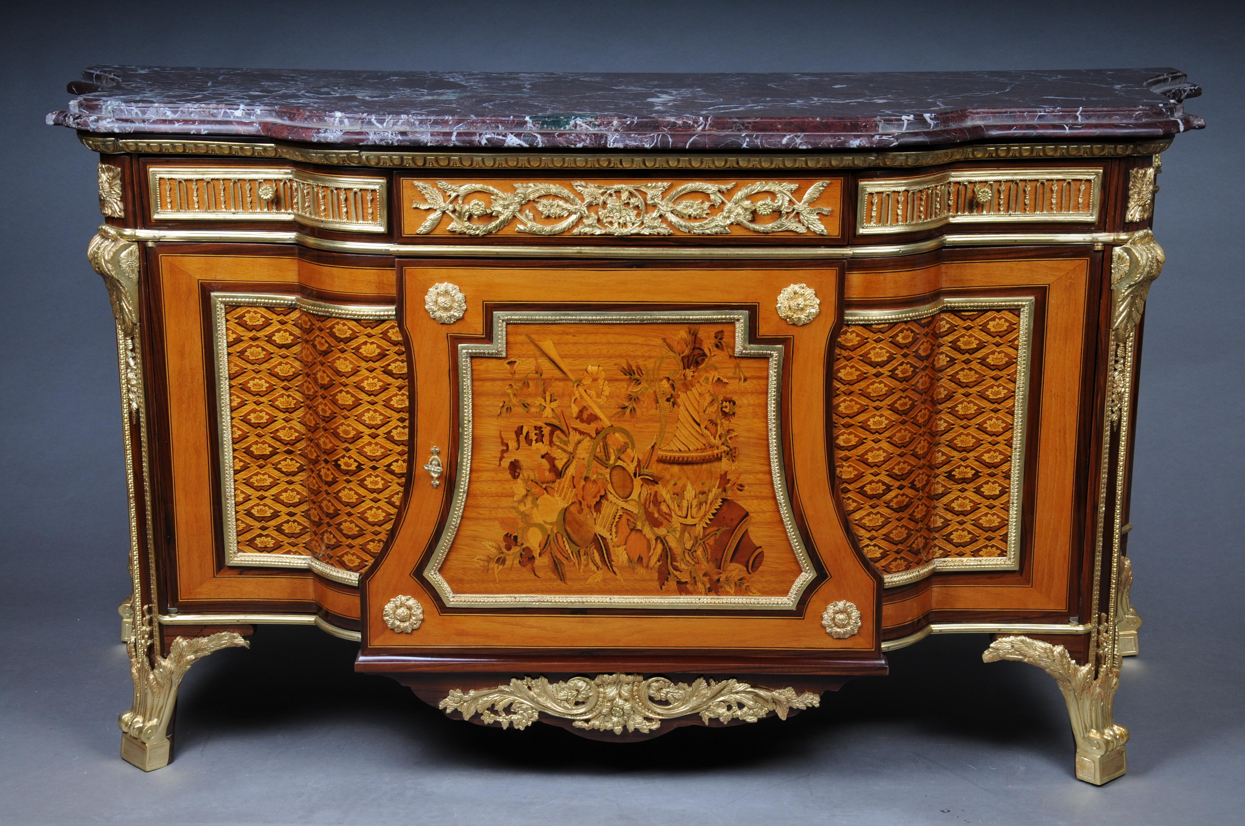 20th Century Louis XVI Style Commode/Chest of Drawers after Jean Henri Riesener

Bronze, gilded or partly dark patinated. Marble plate, over three frying chunks and a large two-thirds chimney door, with amaranth, bergahorn and colorful fruitwood