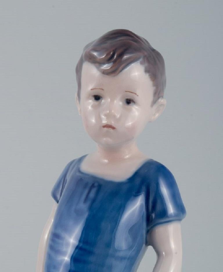 Royal Copenhagen, eine seltene Figur eines Jungen. Modellnummer 519.  (Handbemalt) im Angebot