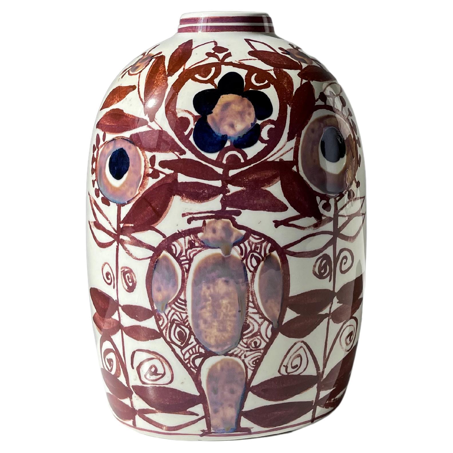 Vase de forme ovale en faïence moderne du milieu du siècle avec un décor floral organique peint à la main dans des couleurs chaudes de brun cannelle, de terre d'ombre claire et de bleu foncé sur une base blanche propre. Les décorations complexes