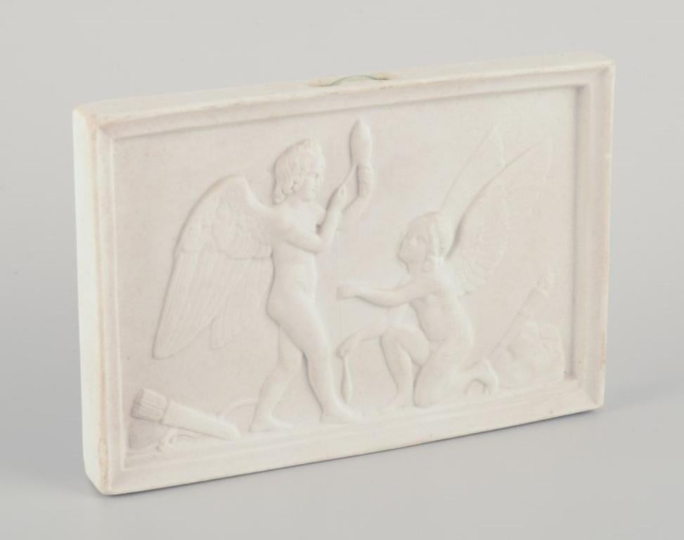 Royal Copenhagen. Amor and Hymen spin the thread of life. 
Biscuit relief after Bertel Thorvaldsen.
Rare motif.
Approximately from 1880.
Marked.
First factory quality.
In excellent condition with microscopic chips on the edge.
Dimensions: 14.0 cm x