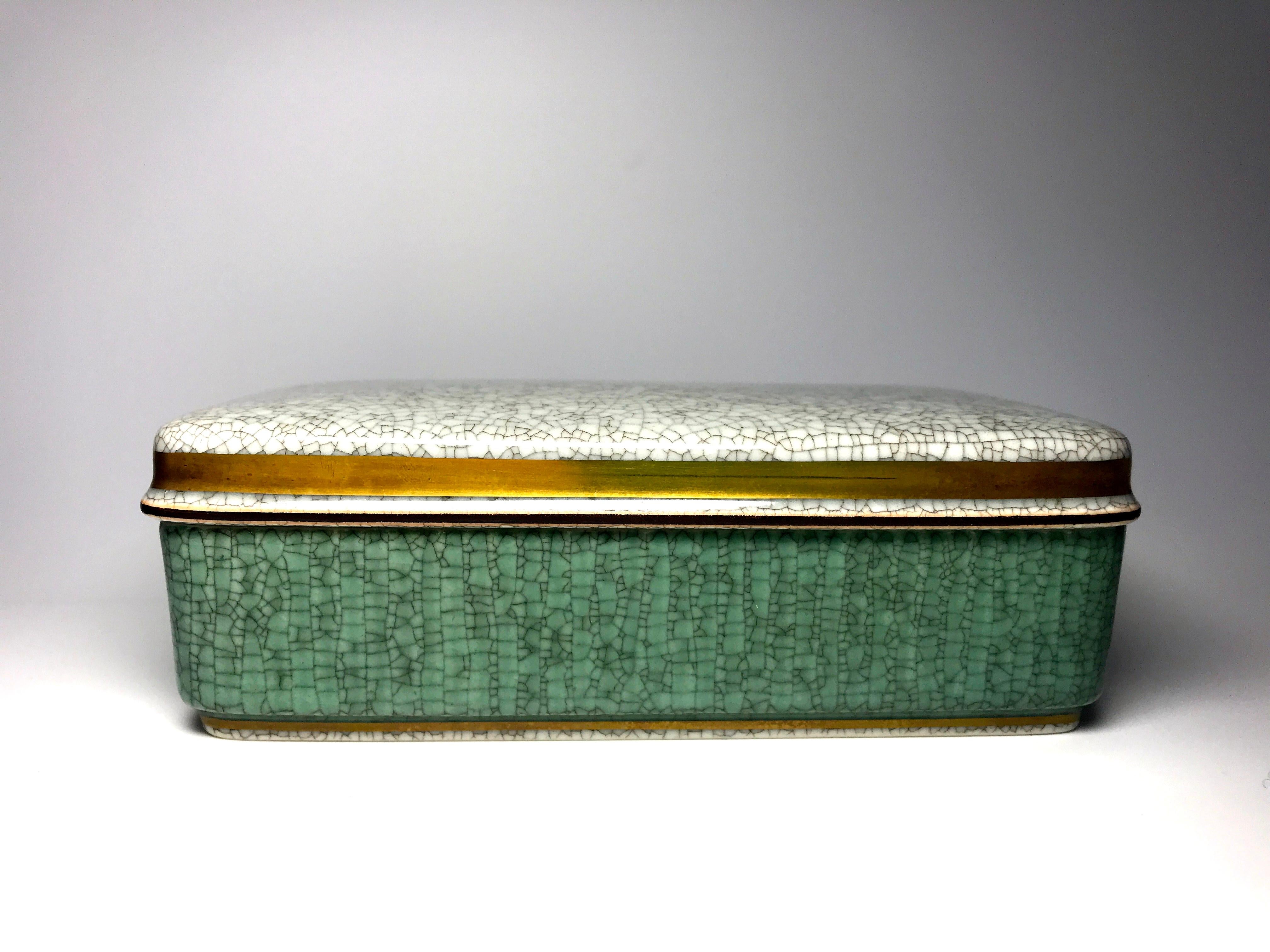 Royal Copenhagen green crackle glaze, oblong porcelain box with grey crackle glaze lid. Decorated with gilt banding. 
Danish understated elegance
Dated 1959
Signed and numbered 3630 
In good condition.