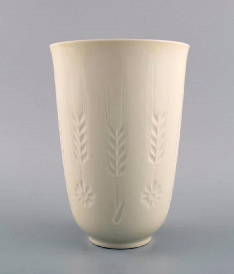 Vase en blanc de chine Royal Copenhagen avec des fleurs et des épis de blé en relief. 
Numéro de modèle 4162. 
Daté de 1975-79.
Mesures : 17.5 x 12 cm.
En parfait état.
Estampillé.
1ère qualité d'usine.