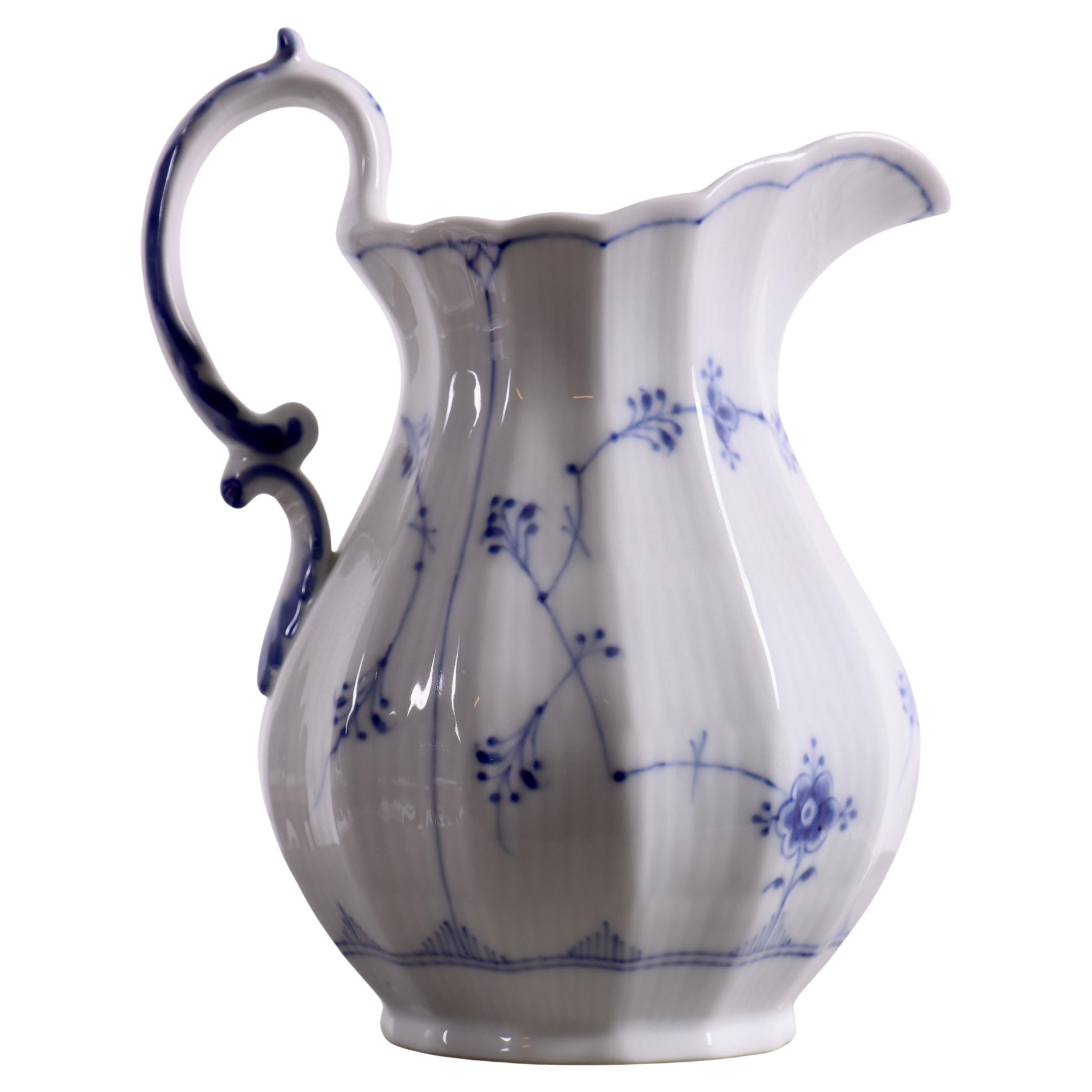 Questa classica brocca di Royal Copenhagen, modello 356, è dipinta con il caratteristico motivo Blue Fluted.

L'iconico motivo blu dipinto a mano comprende fiori delicati e rami sinuosi, accuratamente distribuiti sulla superficie della brocca, che
