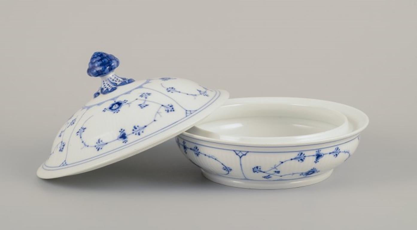 Royal Copenhagen Blue Fluted, eine runde Terrine mit Deckel aus Porzellan.
Frühe 1900er Jahre.
Modellnummer 1/397.
Markiert.
Zweite Fabrikqualität.
Mit mehreren älteren Restaurierungen (siehe Foto).
Abmessungen: D 24,0 cm x H 17,0 cm.