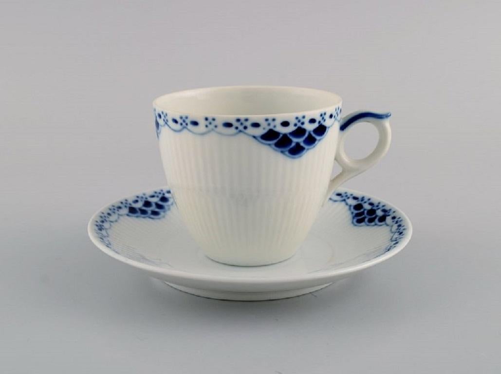 Princesse Royal Copenhagen peinte en bleu. 
Ensemble de cinq tasses à café avec soucoupes et crémier en porcelaine. 
Numéro de modèle 756.
1ère qualité d'usine. En parfait état.
La tasse mesure :  7,5 x 6,5 cm. La soucoupe mesure : 13,3 cm.
Le