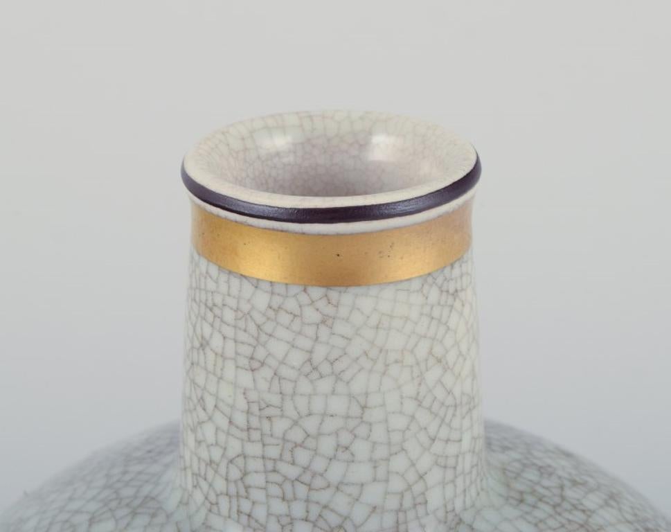 Porcelain Royal Copenhagen, crackled porcelain vase with floral motif and gold decoration. For Sale