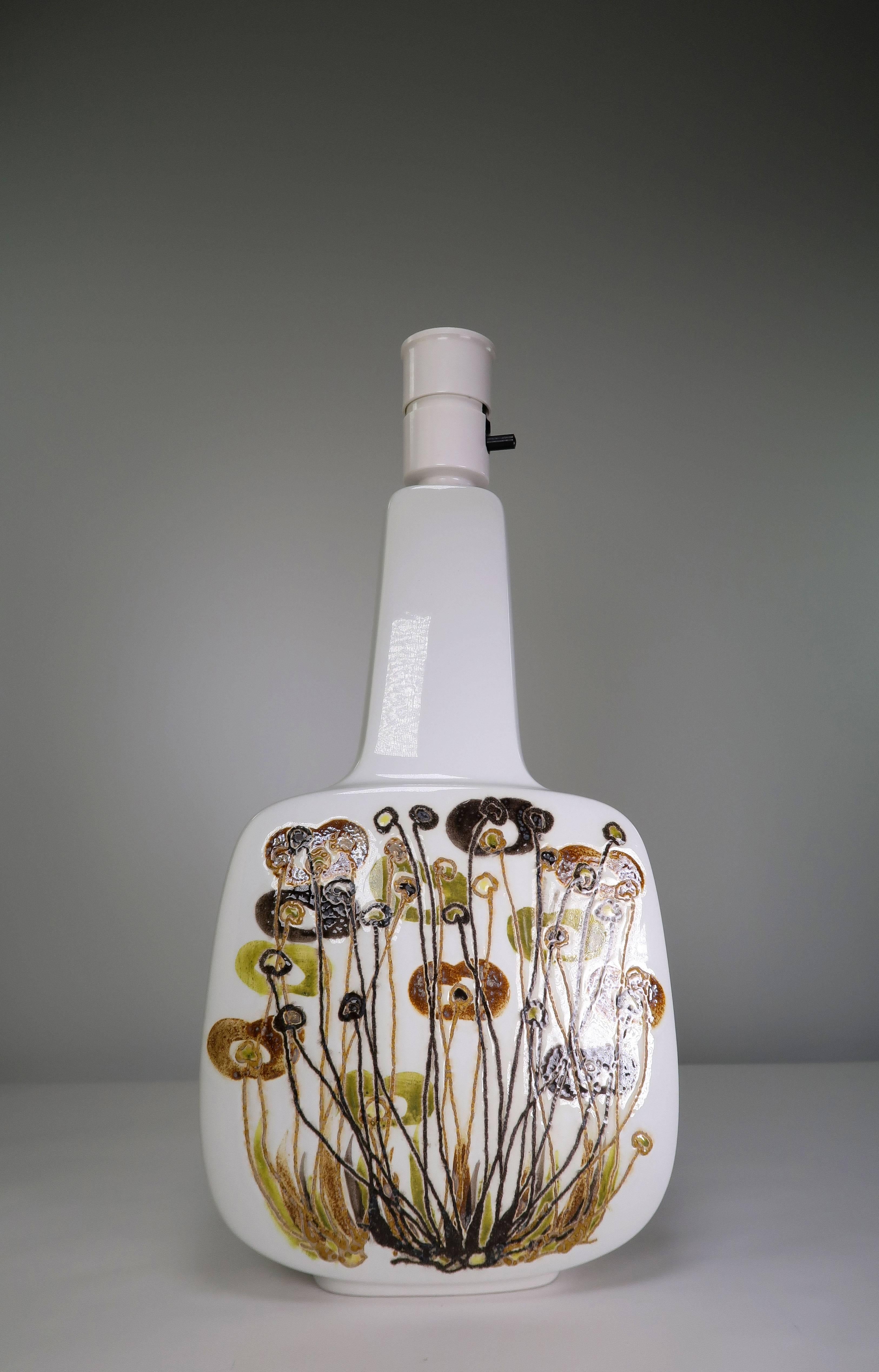 Classic Danish Mid-Century Modern hand painted faience sculptural table lamp by designer Ellen Malmer for Royal Copenhagen. Bone white faience decorated with an organic pattern of light brown, dark brown and green colored glaze depicting a flower