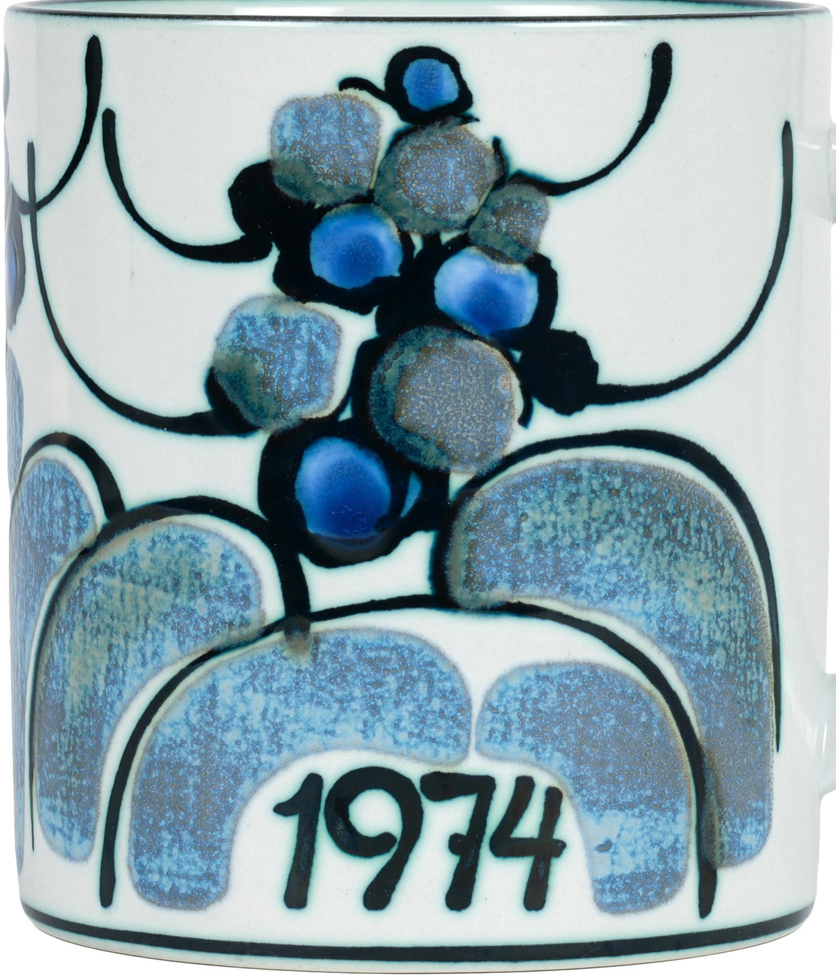 Elegante taza del año de diseño contemporáneo danés Royal Copenhagen, diseñada por Ellen Malmer y fechada en 1974. La taza de porcelana, grande y con asas, tiene forma cilíndrica y se apoya en un borde redondo sin esmaltar con una base ligeramente