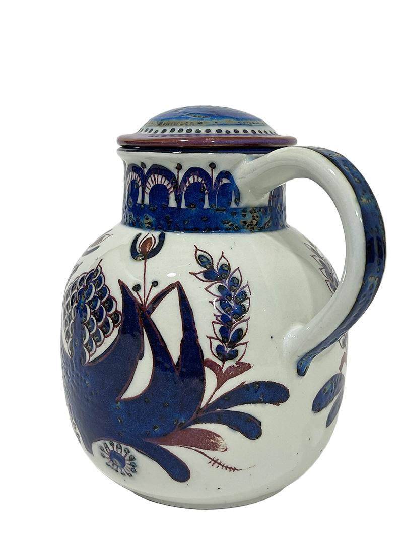 Royal Copenhagen Faience pitcher by Berte Jessen, 1960s

A lidded pitcher from the Danish manufacturer Royal Copenhagen, designed by Berte Jessen, during the 1960s. The lid is marked with the original sticker, signed with initials from Berte and