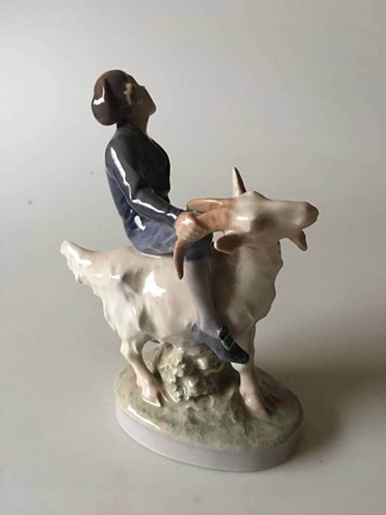 Royal Copenhagen figurine boy on goat #1228 Hans Christian Andersen fairytale. Designed by Christian Thomsen. Is in good condition.