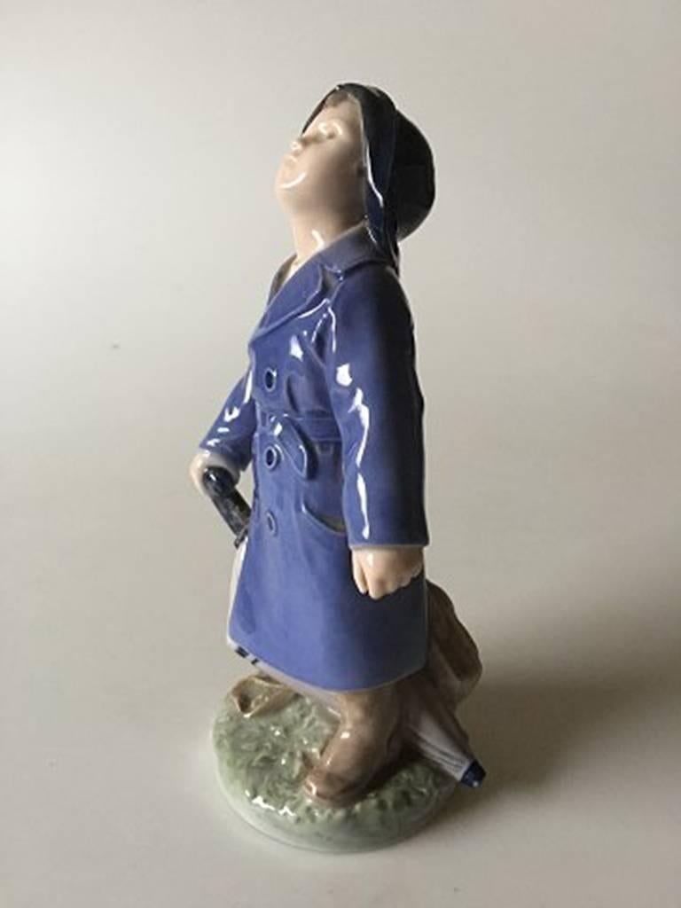Royal Copenhagen figurine garçon avec parapluie #3556. Mesure : 18.5 cm et est en bon état.