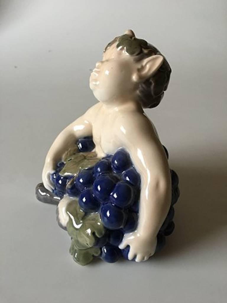 Royal Copenhagen figurine faun with grapes #2361. Measures 14 cm x 13 cm and is in perfect condition.