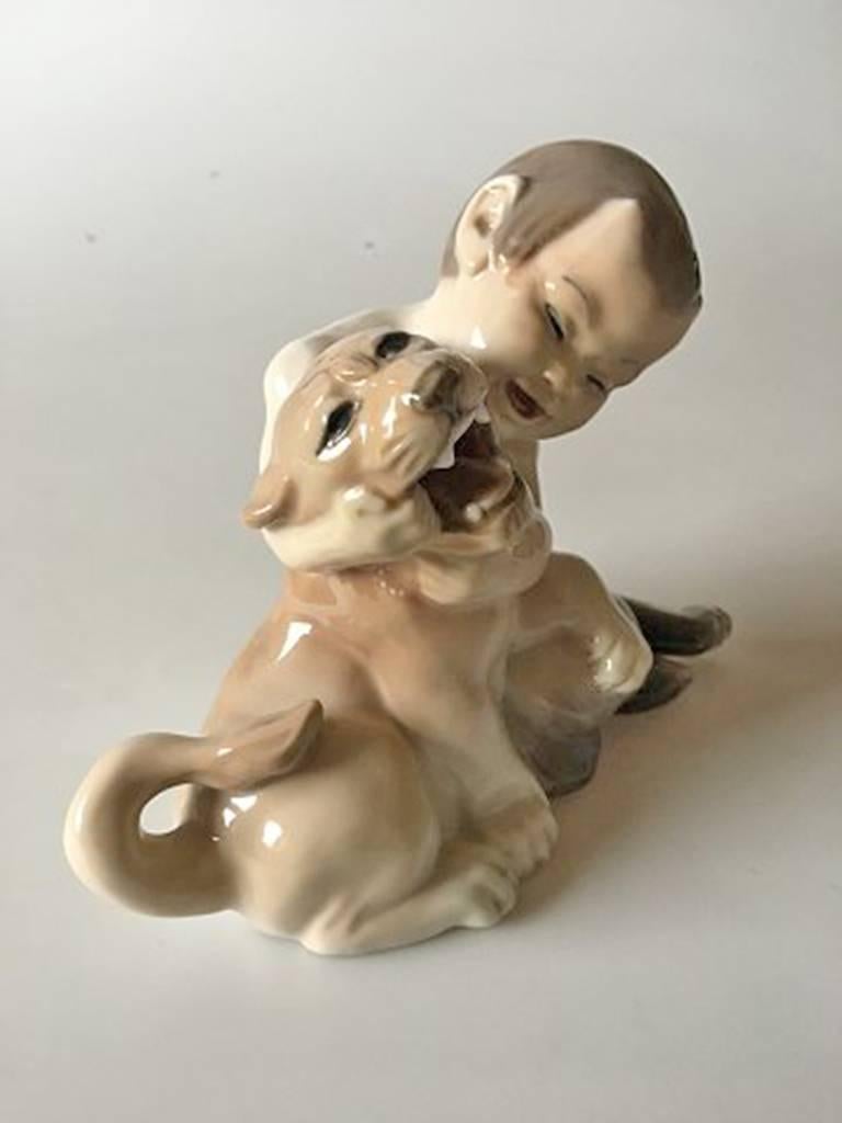 Royal Copenhagen figurine faun with lion cub #2852. Measures: 14cm x 18cm and is in perfect condition.