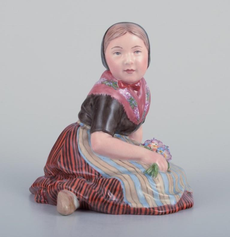 Royal Copenhagen, statuetta in porcellana di una ragazza in abito regionale delle Isole Faroe. 
Sovraverniciato. Vestito in costume regionale e con in mano un bouquet di fiori.
Model No: 12416.
Juliane Marie mark.
Approssimativamente dagli anni