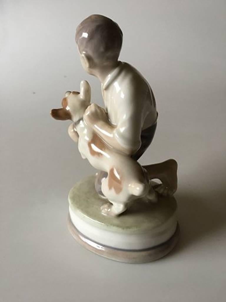 Royal Copenhagen figurine of boy with dog #2140. Measures: 16.5cm and is in good condition.
