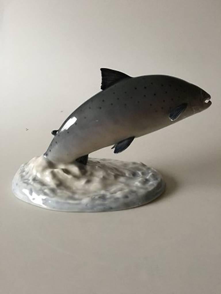 Royal Copenhagen figurine of leaping salmon on base #5456.

Measures: 15.5cm / 6 1/10 in. high and 33cm / 13 in. long

Perfect condition.