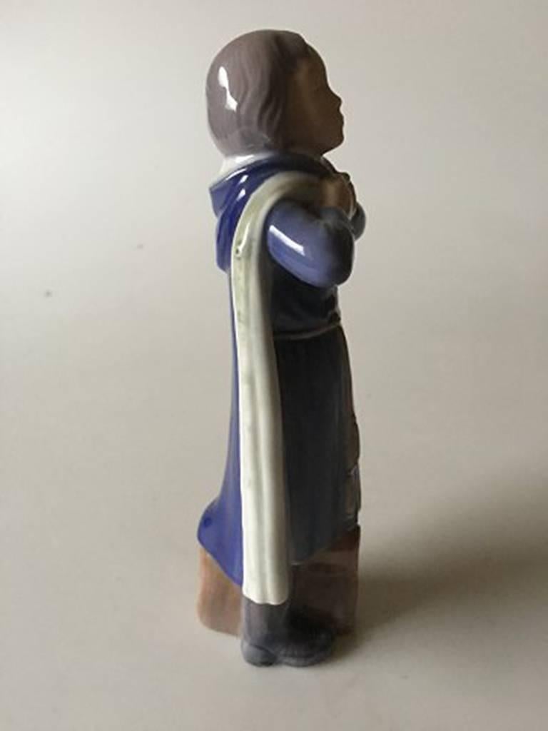 Royal Copenhagen figurine of schoolboy with cloak and bag #4503. By Holger Christensen. First quality in perfect condition. Measures: 19 cm H (7 31/64 in.)