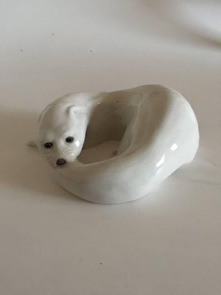 Royal Copenhagen figurine otter biting its tail #776. Measures 7cm x 19m and is in good condition. Marked as a second. Designed by Knud Kyhn in 1906.