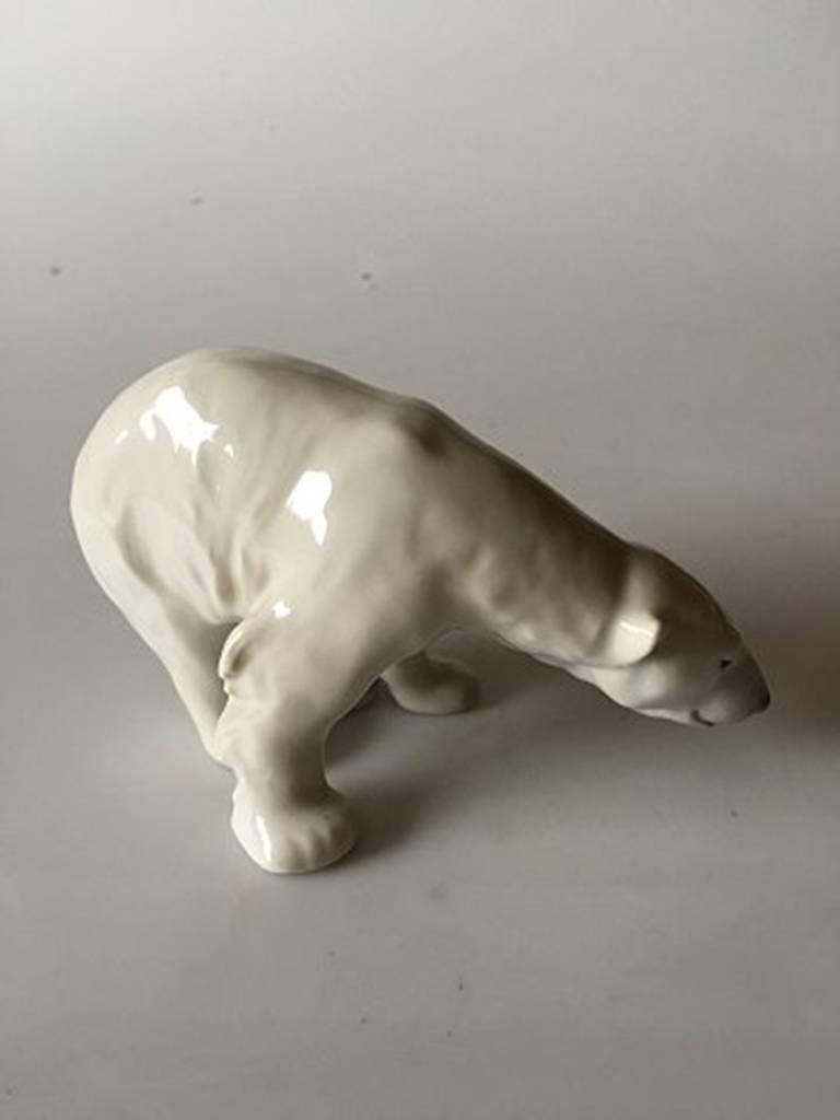 Royal Copenhagen figurine polar bear feeding #321. Measures 9cm x 14cm and is in good condition. Designed by Carl Johan Bonnesen.