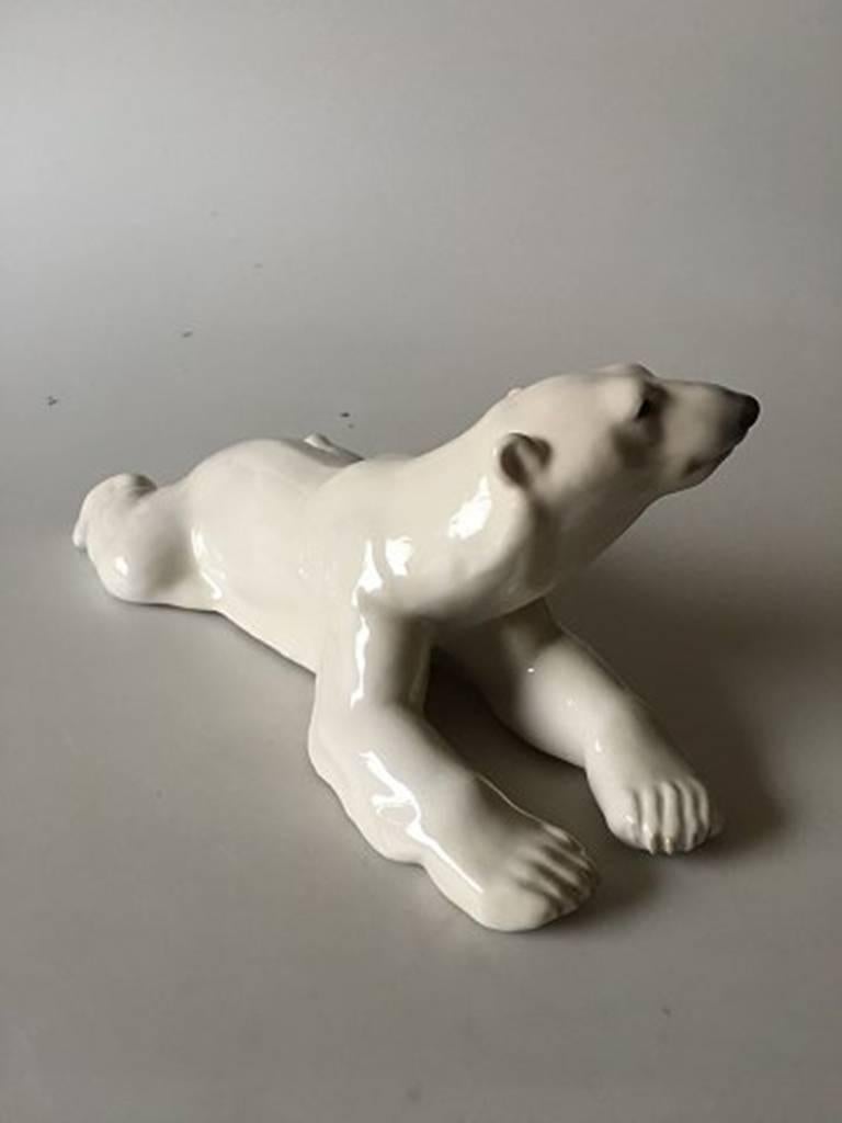 Royal Copenhagen figurine polar bear laying on stomach #1250. Measures: 31cm x 13cm and is in good condition.