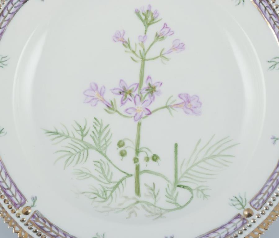 Royal Copenhagen Flora Danica
Plato llano de porcelana pintada a mano con flores y decoración dorada. Pintado fuera de la fábrica.
Datación: Aprox. años 1930/40
Nombres latinos y daneses.
En excelente estado.
Segunda calidad de