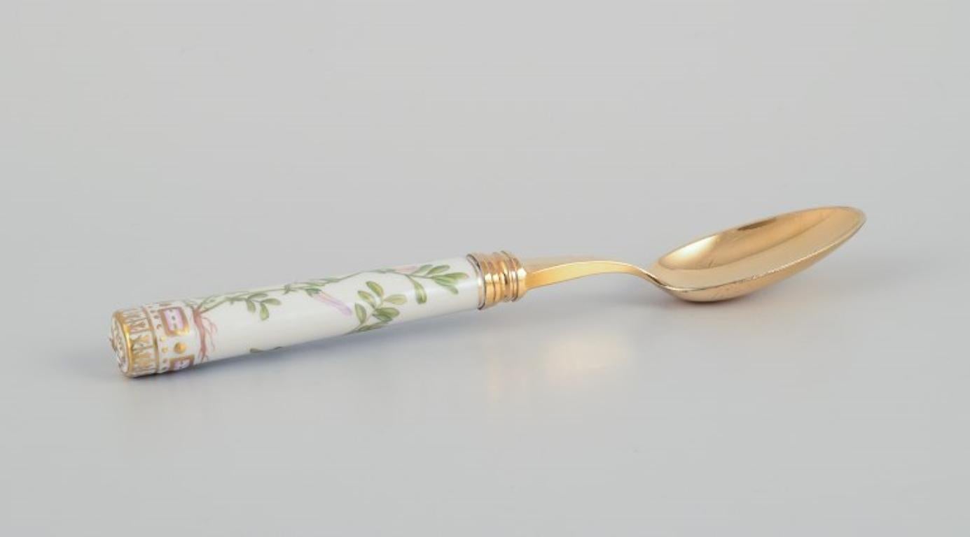 Royal Copenhagen Flora Danica/Georg Jensen. 
Dining spoon with a porcelain handle, hand-painted with Flora Danica motif. 
A spoon's bowl by Georg Jensen in gilt sterling silver.
1970s/80s.
In good condition with two hairline cracks. See