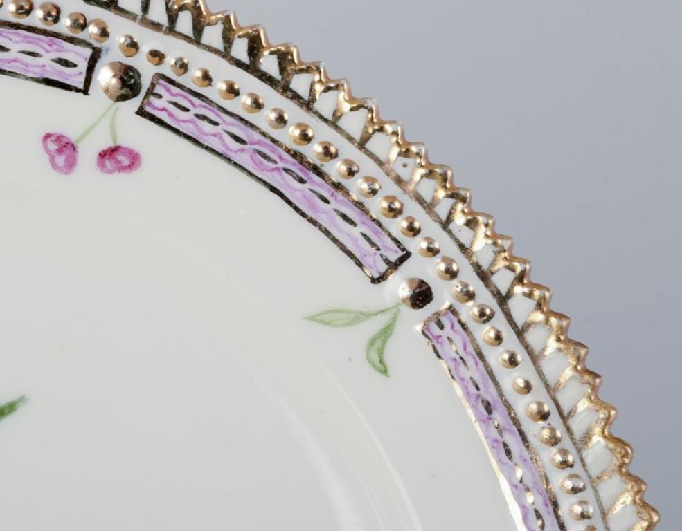 Royal Copenhagen Flora Danica. Lunch plate in hand-painted porcelain with flowers and gold decoration. 
Painted outside the factory.
Dating: 1949
Latin and Danish names.
In excellent condition.
Second factory quality.
Marked.
Diameter: 22.0 cm.
