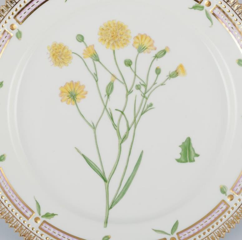 Piatto da pranzo Flora Danica di Royal Copenhagen in porcellana dipinta a mano con fiori e decorazioni in oro. 
Model No: 20/3572
Datazione: 1963
Nome latino.
In perfette condizioni.
Prima qualità di fabbrica.
Contrassegnato.
Diametro: 22,3 cm.