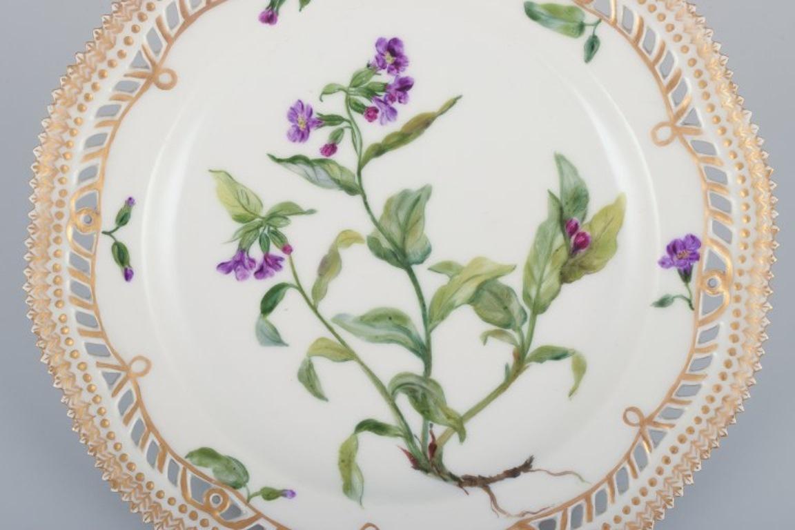 Royal Copenhagen Flora Danica, open lace lunch plate. 
Latin text. Decorated outside the factory.
Early 1900s.
Marked.
Perfect condition.
Second factory quality.
Diameter 21.8 cm.
