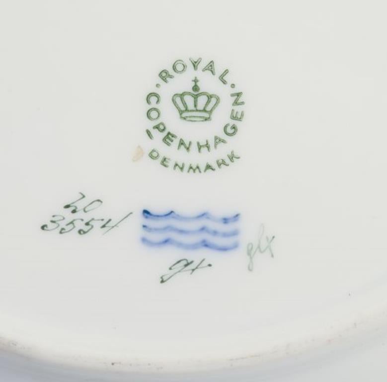 Piatto da pranzo traforato Flora Danica di Royal Copenhagen in porcellana dipinta a mano con fiori e decorazioni in oro. 
Model No: 20/3554
Datazione: 1964
Nome latino.
In perfette condizioni.
Prima qualità di fabbrica.
Contrassegnato.
Diametro: