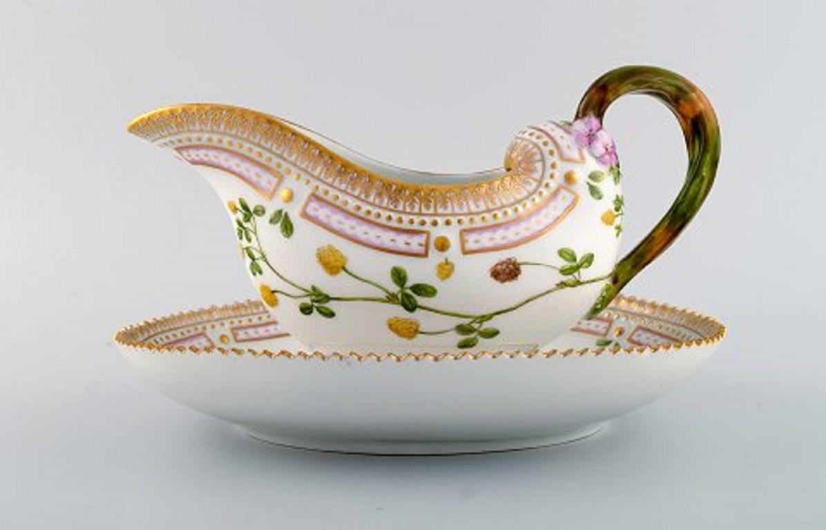 Royal Copenhagen Flora Danica sauce boat in hand painted porcelain with flowers and gold decoration. 
Model number 20/3556.
Measures: 25 x 17 x 13 cm.
In perfect condition.
1st factory quality.
Stamped.