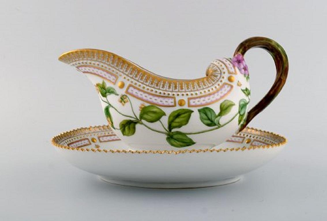 Royal Copenhagen Flora Danica sauce boat in hand painted porcelain with flowers and gold decoration. 
Model number 20/3556.
Measures: 25 x 17 x 13 cm.
In perfect condition.
1st factory quality.
Stamped.