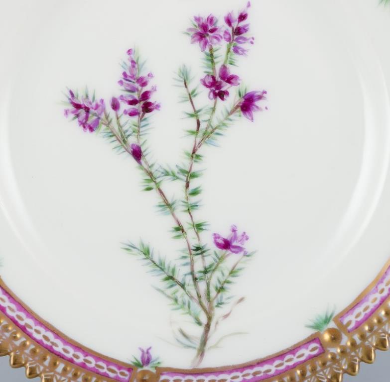 Royal Copenhagen Flora Danica. Side plate in hand-painted porcelain with flowers and gold decoration. 
Painted outside the factory.
Latin name.
In excellent condition.
Second factory quality.
Marked.
Diameter: 14.0 cm.