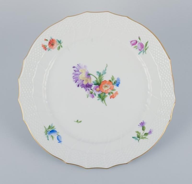 Royal Copenhagen, four Saxon Flower dinner plates. 
Hand-painted with different polychrome flower motifs.
Model number 493/1710.
Approximately 1956.
Marked.
First factory quality.
In excellent condition with minimal signs of use.
Provenance: Hotel