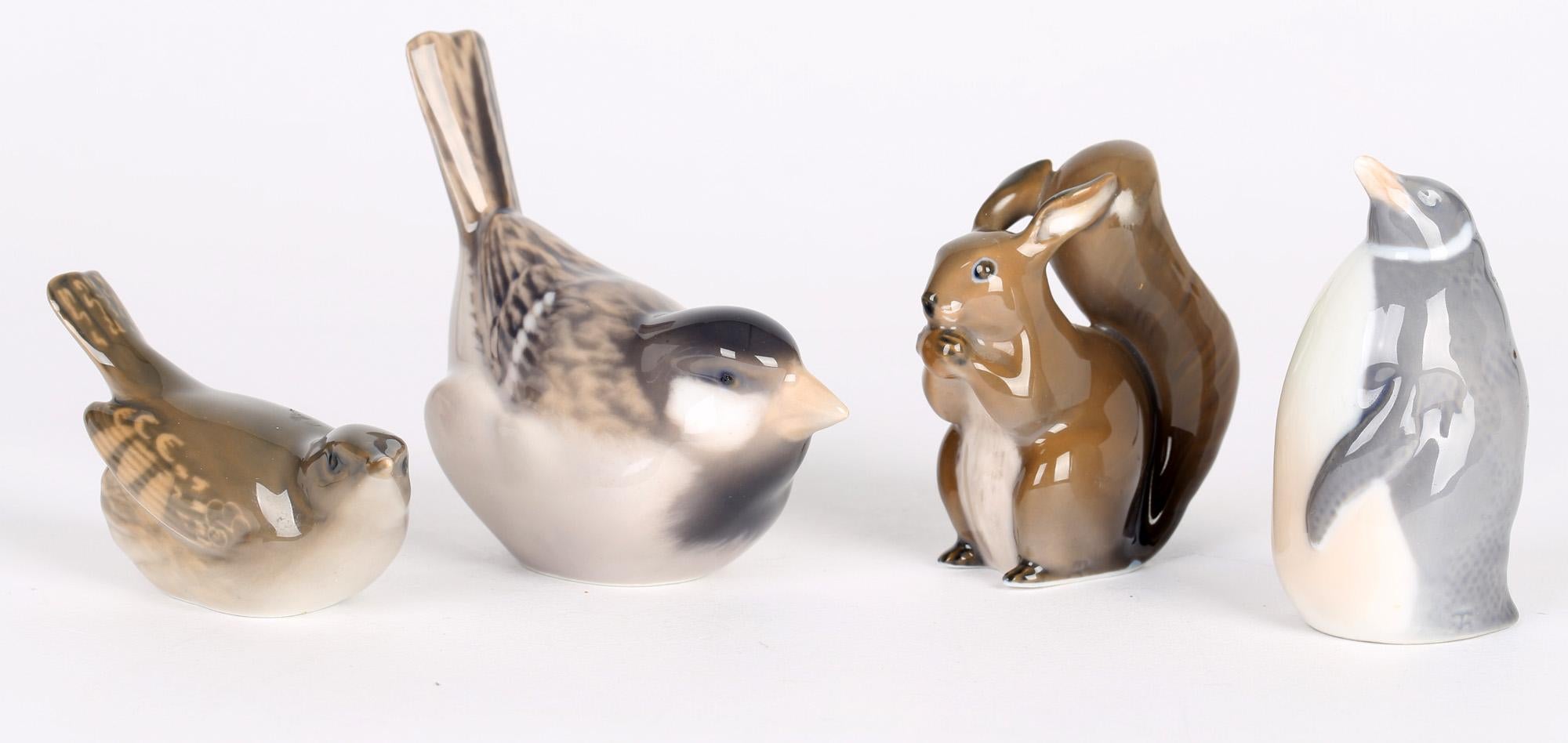 Quatre oiseaux et écureuils en porcelaine danoise fabriqués par Royal Copenhagen et datant des années 1960. Les figures sont bien modelées et peintes à la main dans des tons de bleu, de brun et de rouge sur un fond blanc. Elles comprennent un grand