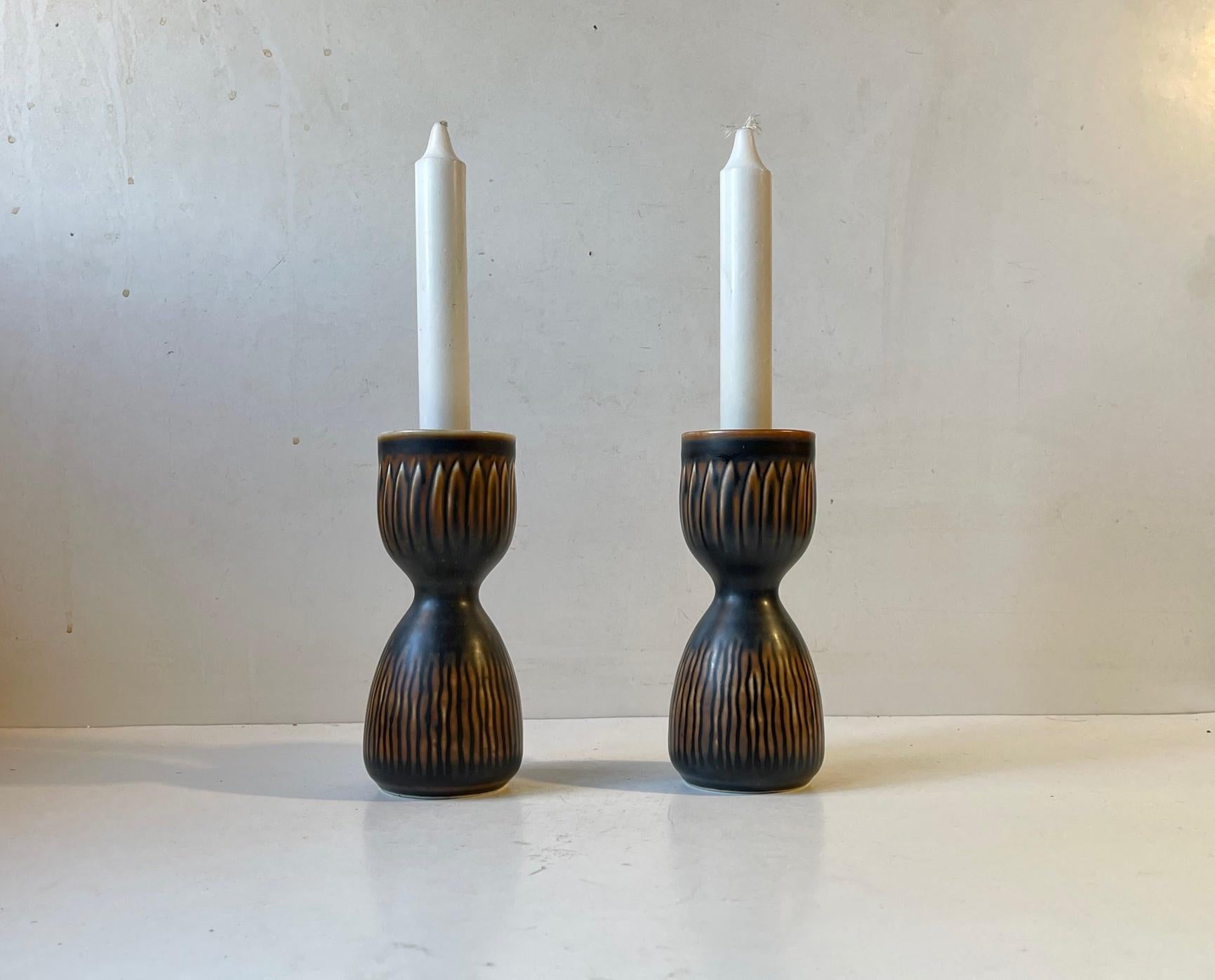 Rari pezzi ispirati ad Axel Salto di Royal Copenhagen. Vasi o candelabri in gres a forma di clessidra disegnati da Gerd Bogelund negli anni '50 o nei primi anni '60. Decorato con uno smalto principale marrone scuro quasi nero e con impressioni
