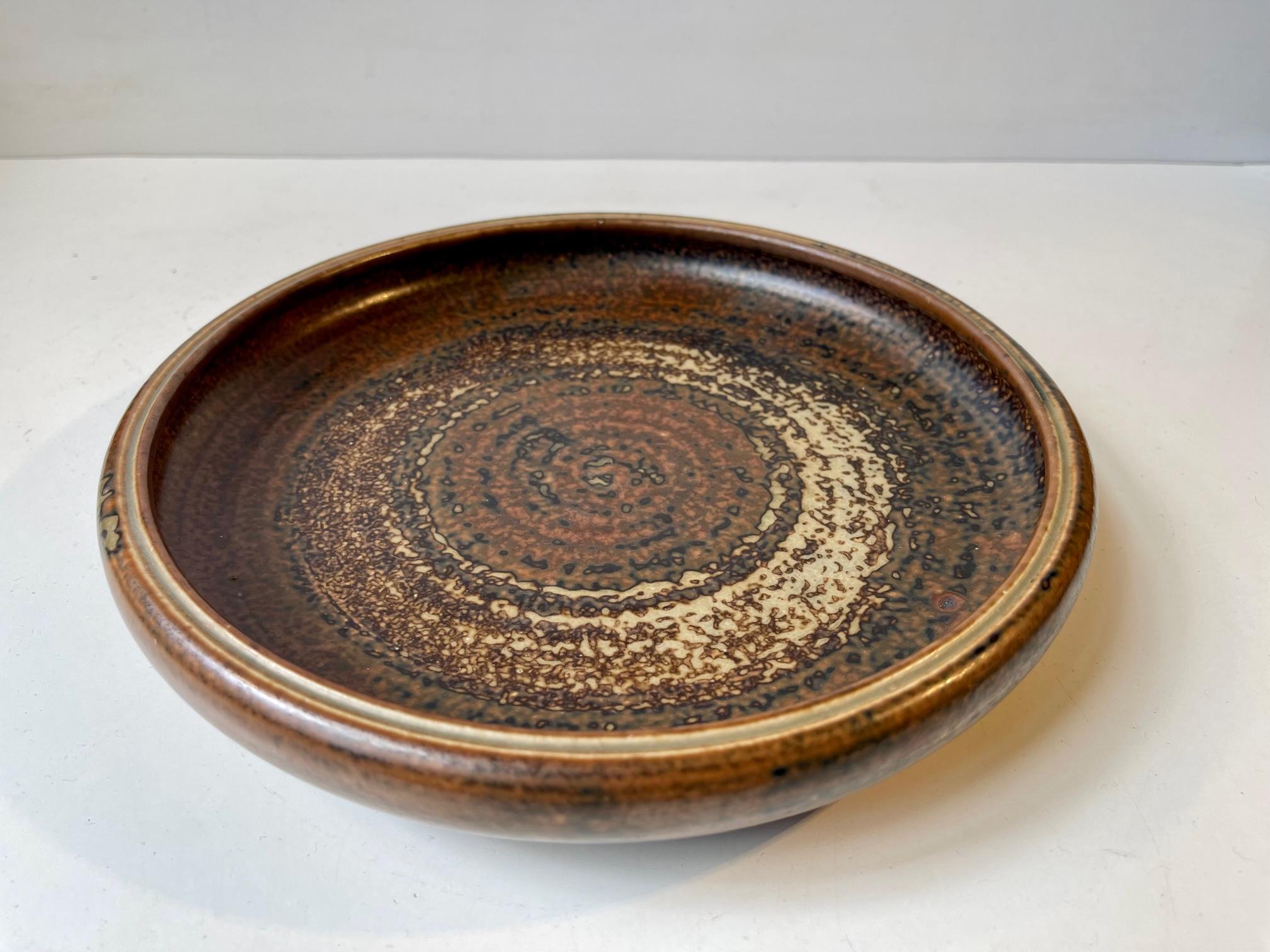 Glazed stoneware bowl/dish designed by the danish ceramist Carl Halier. Manufactured at Royal Copenhagen during the 1950s in a style reminiscent of Bode Willumsen and Axel Salto. Fully signed. and numbered. Measurements: D: 24 cm, H: 4.5 cm.