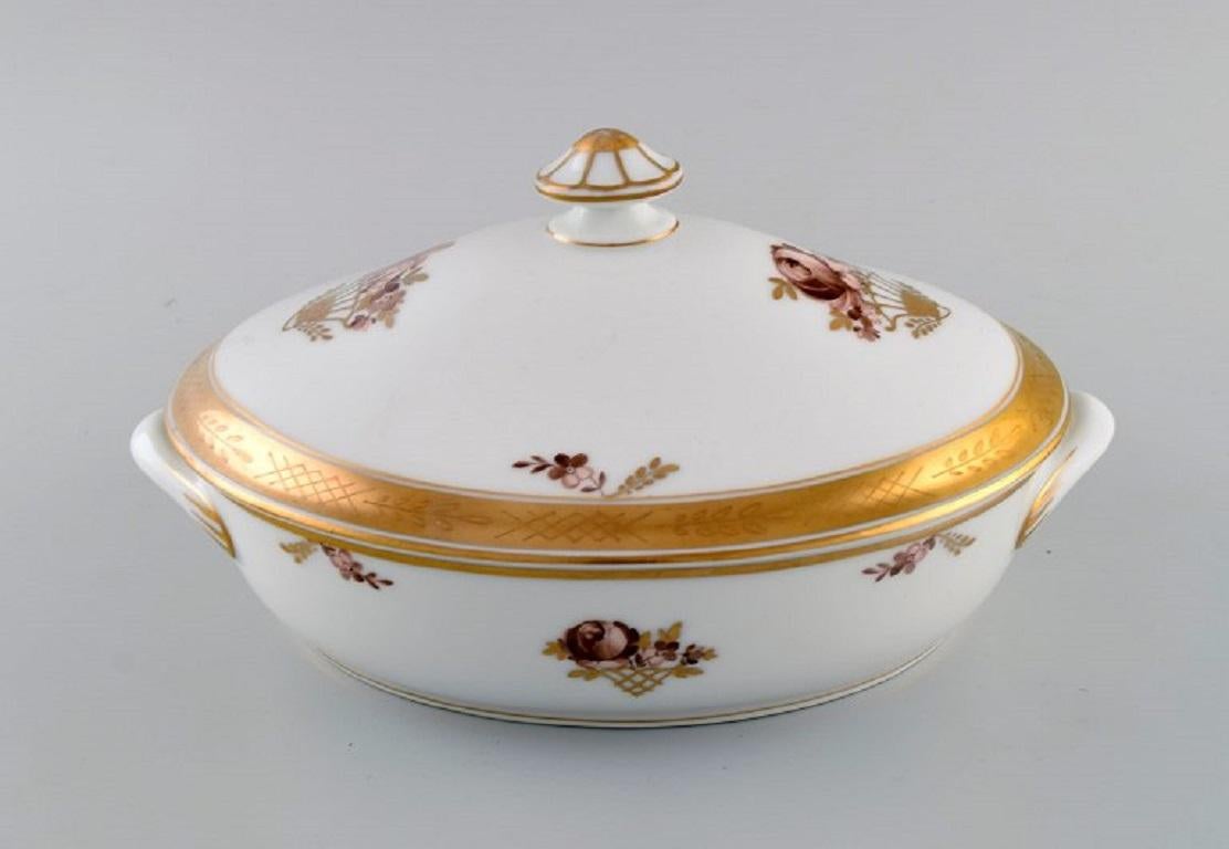 Royal Copenhagen Golden Basket lidded tureen in porcelain with flowers and gold decoration. 
Model number 595/9348. 
Early 20th century.
Measures: 27 x 18.5 cm.
Height: 13 cm.
In excellent condition.
Stamped.
1st factory quality.