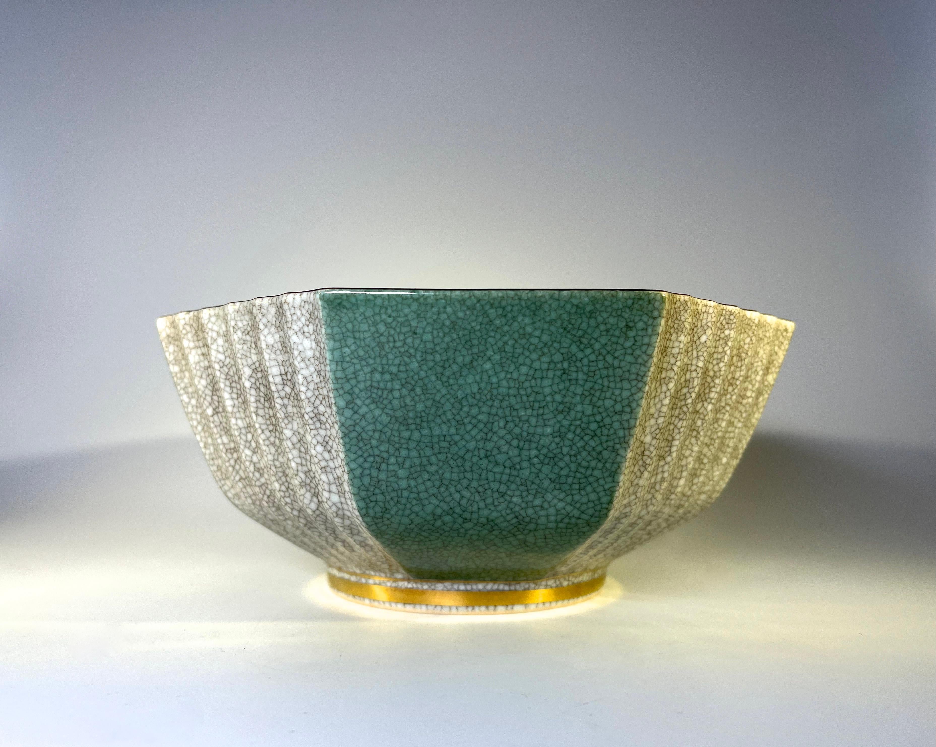 Royal Copenhagen porcelain gilded pale green and grey crackle glazed hexagonal shaped bowl
Pale green and fluted grey crackle glazed panels alternate the exterior, gilded band to base
Grey crackle glaze interior and fine dark brown rim
Circa