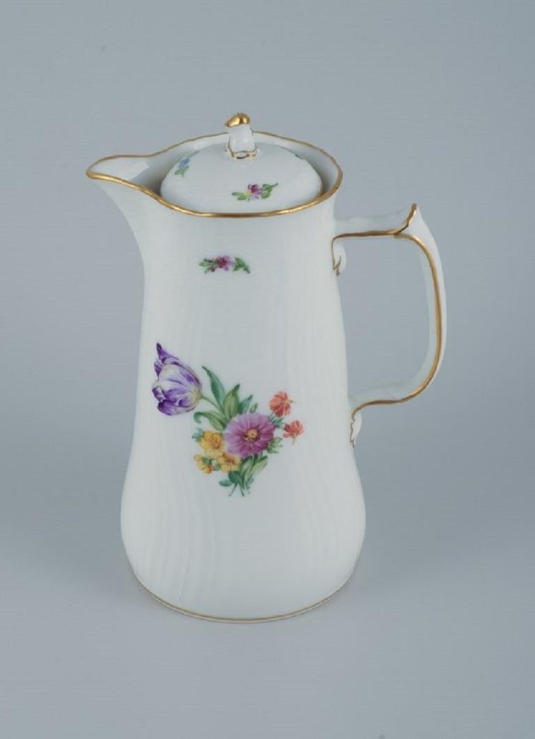 Royal Copenhagen light saxon flower. 
Chocolate pitcher in hand-painted porcelain.
Model number 493/1513.
Approx. 1920s.
In excellent condition.
Marked.
First factory quality.
Dimensions: D 16.0 with handle x 23.5 cm. with lid.