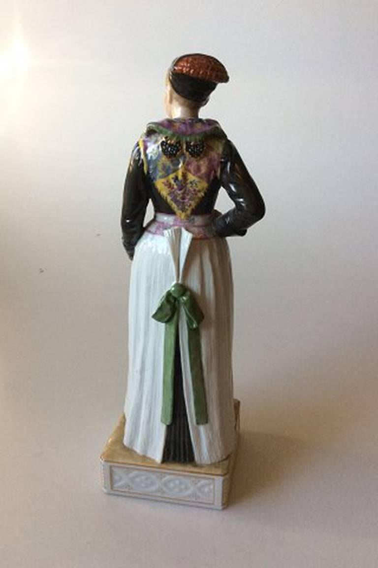 Royal Copenhagen over-glaze figurine in National dress 12104 cook's costume, amager girl.

Designed by Carl Martin-Hansen (1877-1941).

Measures: 30 cm / 11 4/5 inches.