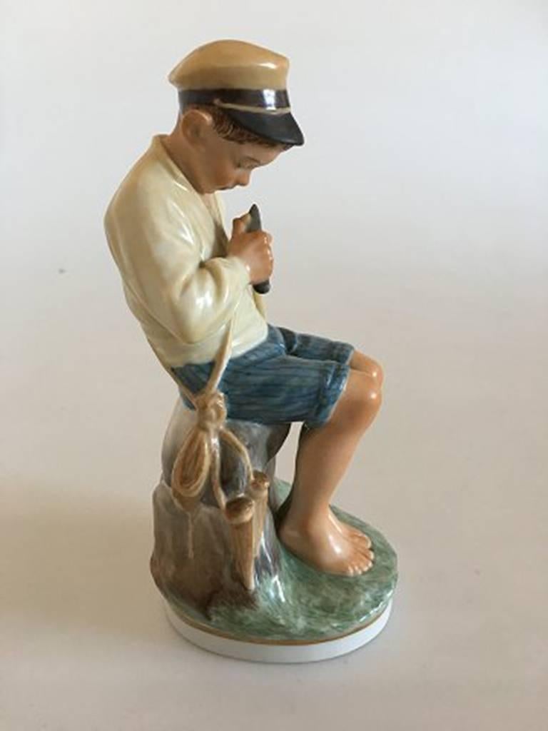 Royal Copenhagen over glaze figurine boy cutting stick #905. 

Measures 18cm / 7 1/10 in.