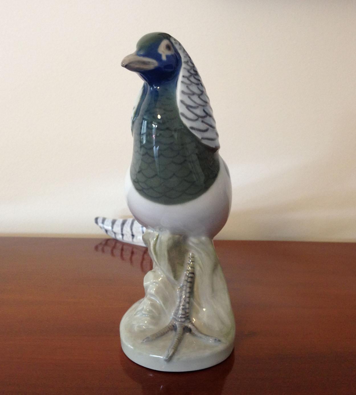 A Royal Copenhagen Pheasant figurine, model number 1881, in soft pastel shades of blue, grey and pink.

Designed by A. Nielsen

Date Mark for 1968.

A factory first in excellent condition with no chips, cracks or restoration.