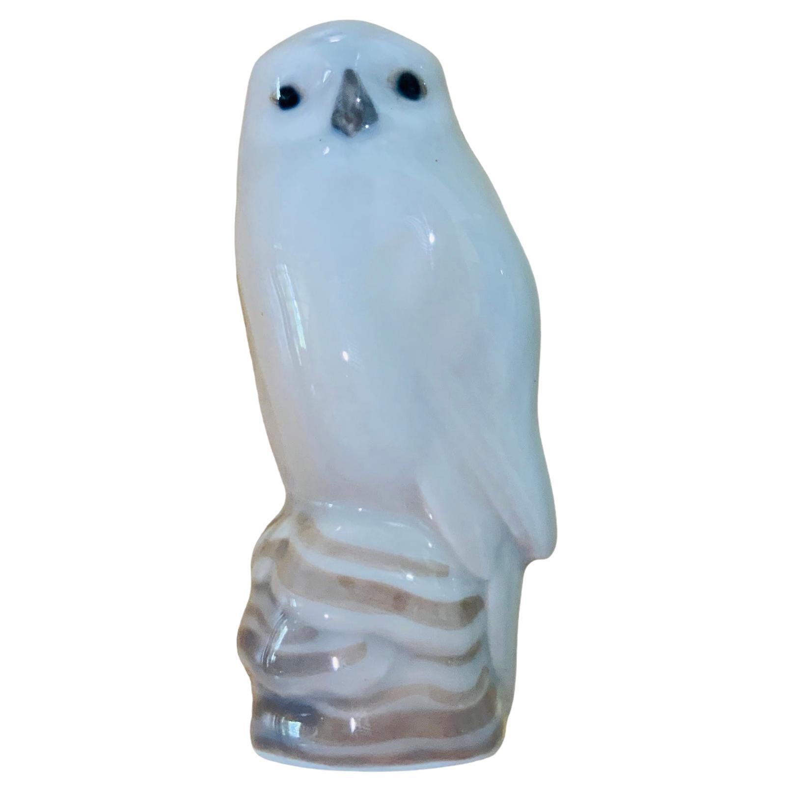 This is a Royal Copenhagen porcelain of small and proud bird figurine known as a snowy owl. At the base is the Royal Copenhagen hallmark with the number-1741, a crown and Denmark. It is hand painted white and grey.