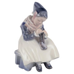 Royal Copenhagen porcelain figurine. Amager girl in traditional dress knitting.