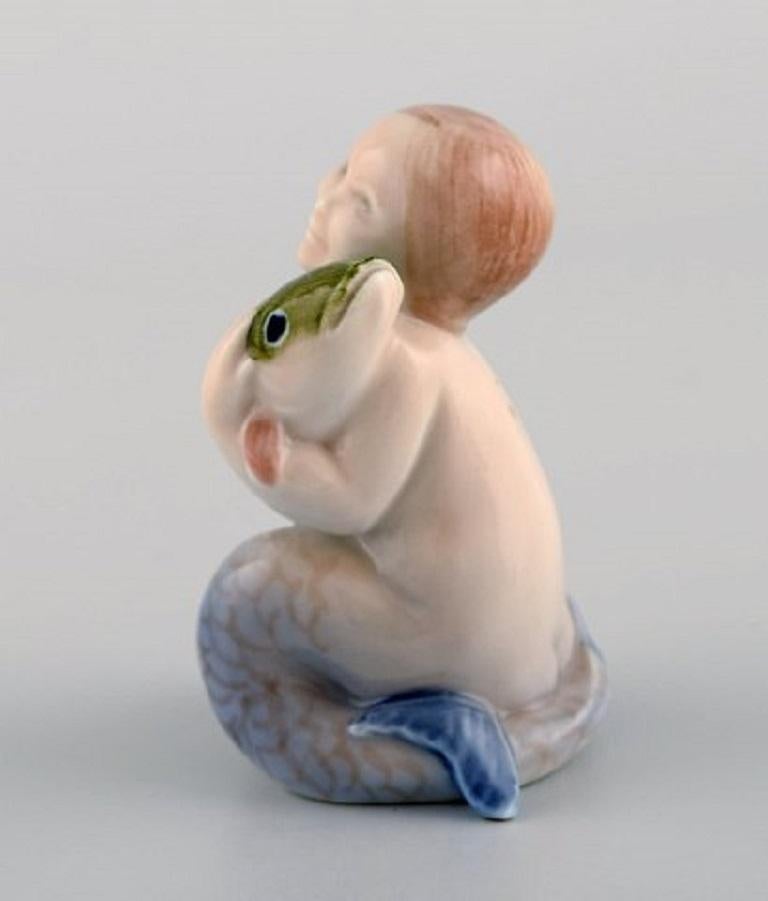 Royal Copenhagen porcelain figurine. Mermaid with a fish, 1920s. Model number 2348.
Measures: 6.5 x 5.5 cm.
In excellent condition.
Stamped.
1st factory quality.