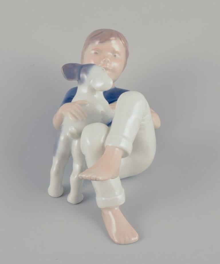 Porcellana Royal Copenhagen. Statuetta in porcellana di un ragazzo con un cucciolo. Rara statuetta. in vendita