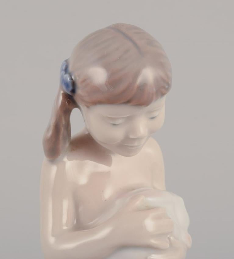 Smaltato Statuetta in porcellana di Royal Copenhagen raffigurante una ragazza con un coniglio. in vendita
