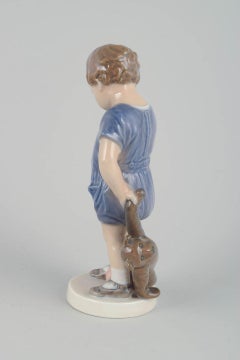 Royal Copenhagen. Porcelain figurine of small boy with teddy bear.