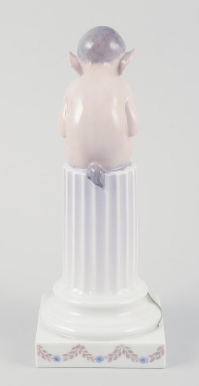 Porcelain Royal Copenhagen, porcelain figurine. Whistling Pan sitting on a pedestal. For Sale